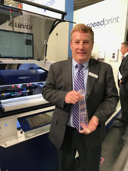 Mark Brawley shows off the Global SMT Award on Speedprint’s booth at Productronica. 